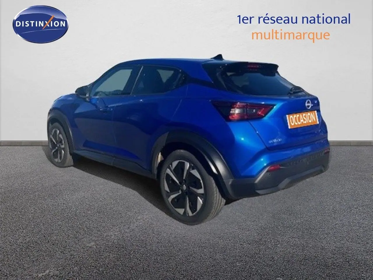 Nissan Juke bleu magnétique 3/4 arrière côté gauche, avec jantes noires et détails noirs contrastants.