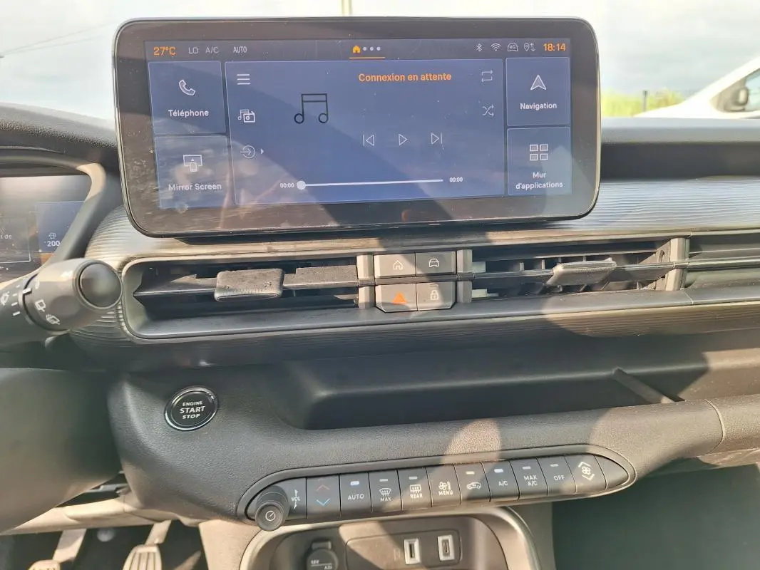 Vue rapprochée de la console centrale du Jeep Avenger blanc 2025, avec écran tactile et commandes climatisation.