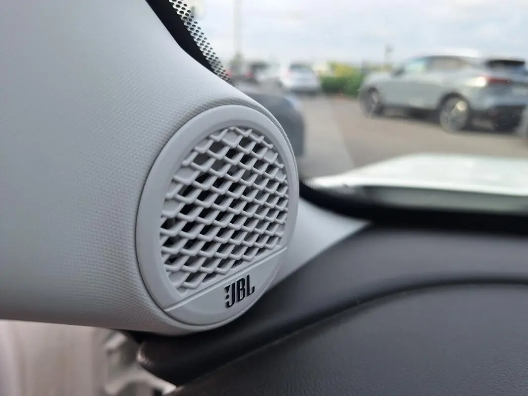 Gros plan sur l'enceinte JBL intégrée au tableau de bord du Jeep Avenger blanc, vue intérieure côté gauche.