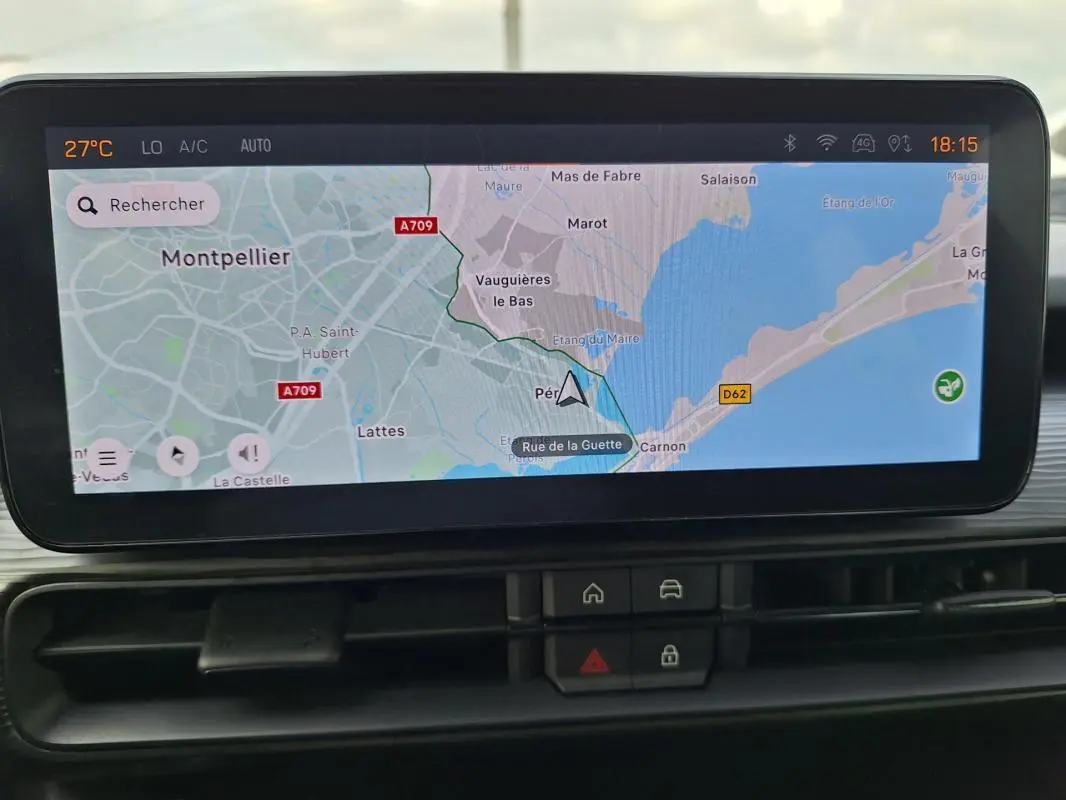 Écran tactile intérieur montrant la navigation GPS avec carte de Montpellier, boutons de commande en dessous.