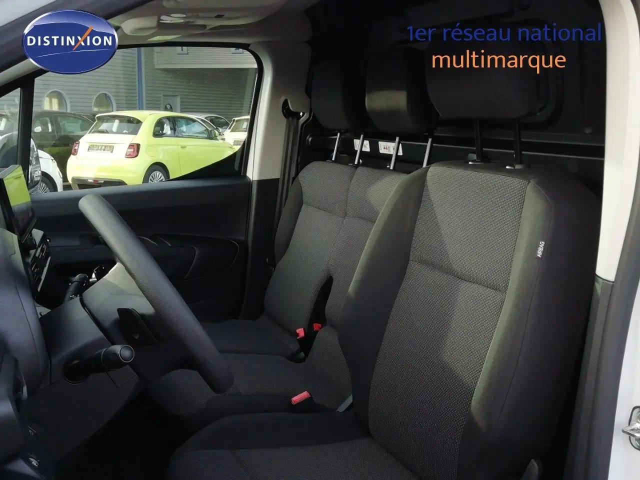 Vue intérieure côté conducteur du Citroën Berlingo XL blanc Icy, montrant les sièges tissu gris et le volant multifonction.