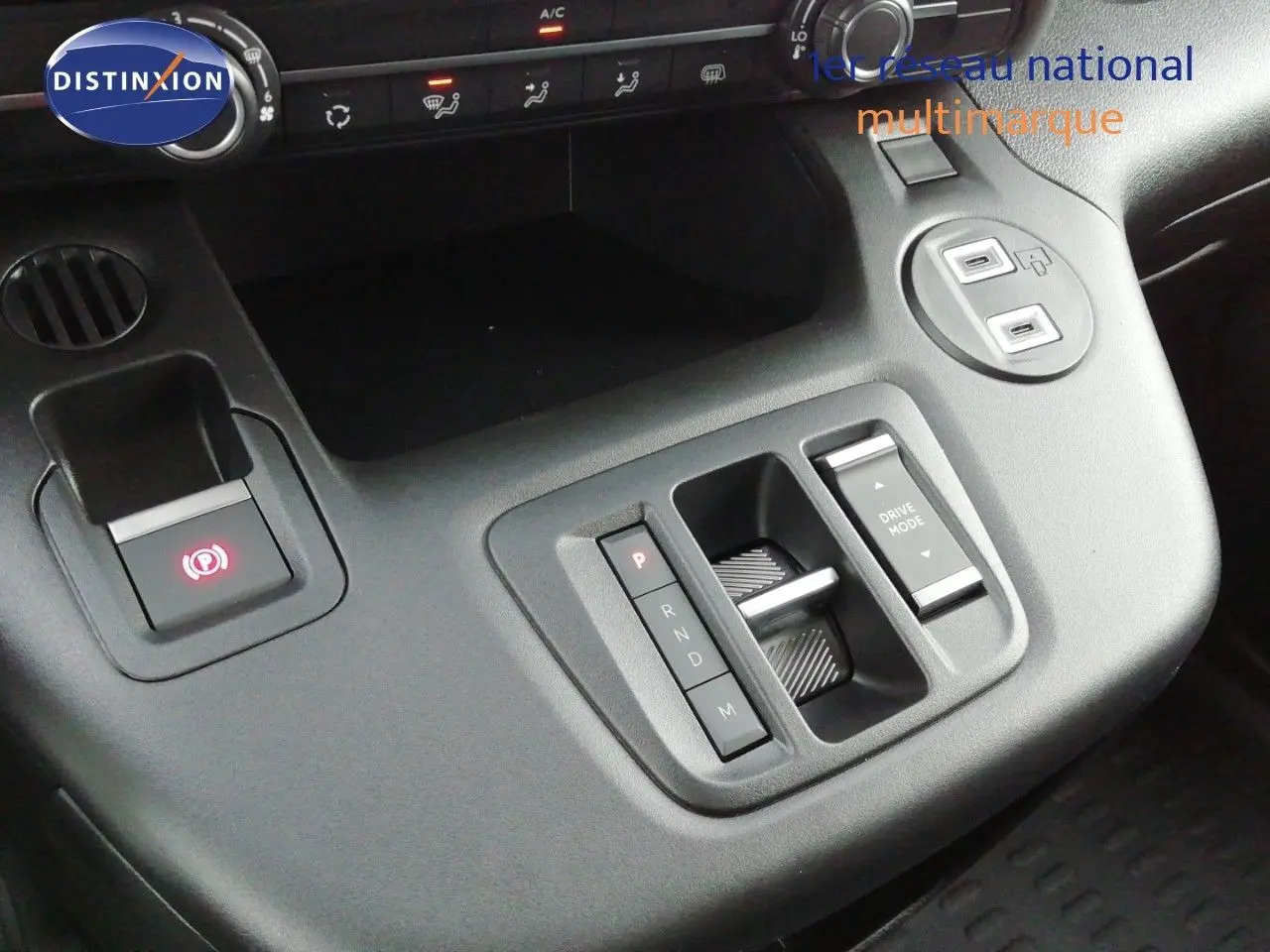 Vue rapprochée de la console centrale du Citroën Berlingo XL 2026, avec commandes de boîte auto et bouton frein à main électrique.