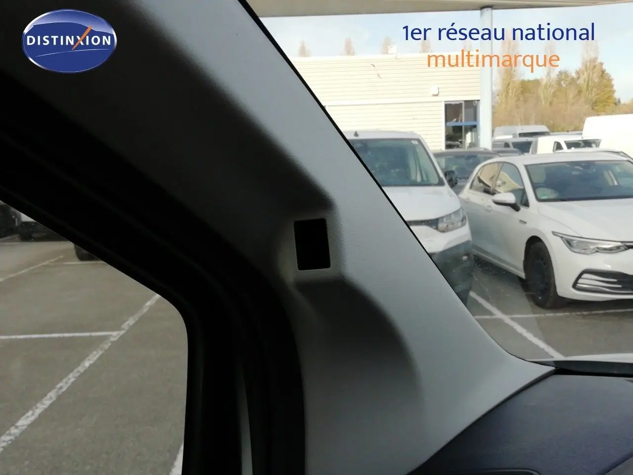 Vue intérieure côté gauche du pare-brise du Citroën Berlingo XL blanc icy, avec parking en arrière-plan.