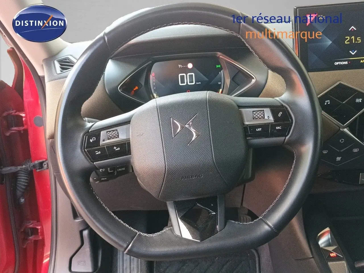 Vue rapprochée du volant en cuir noir du DS3 Crossback rouge, avec tableau de bord numérique et partie centrale du poste de conduite.