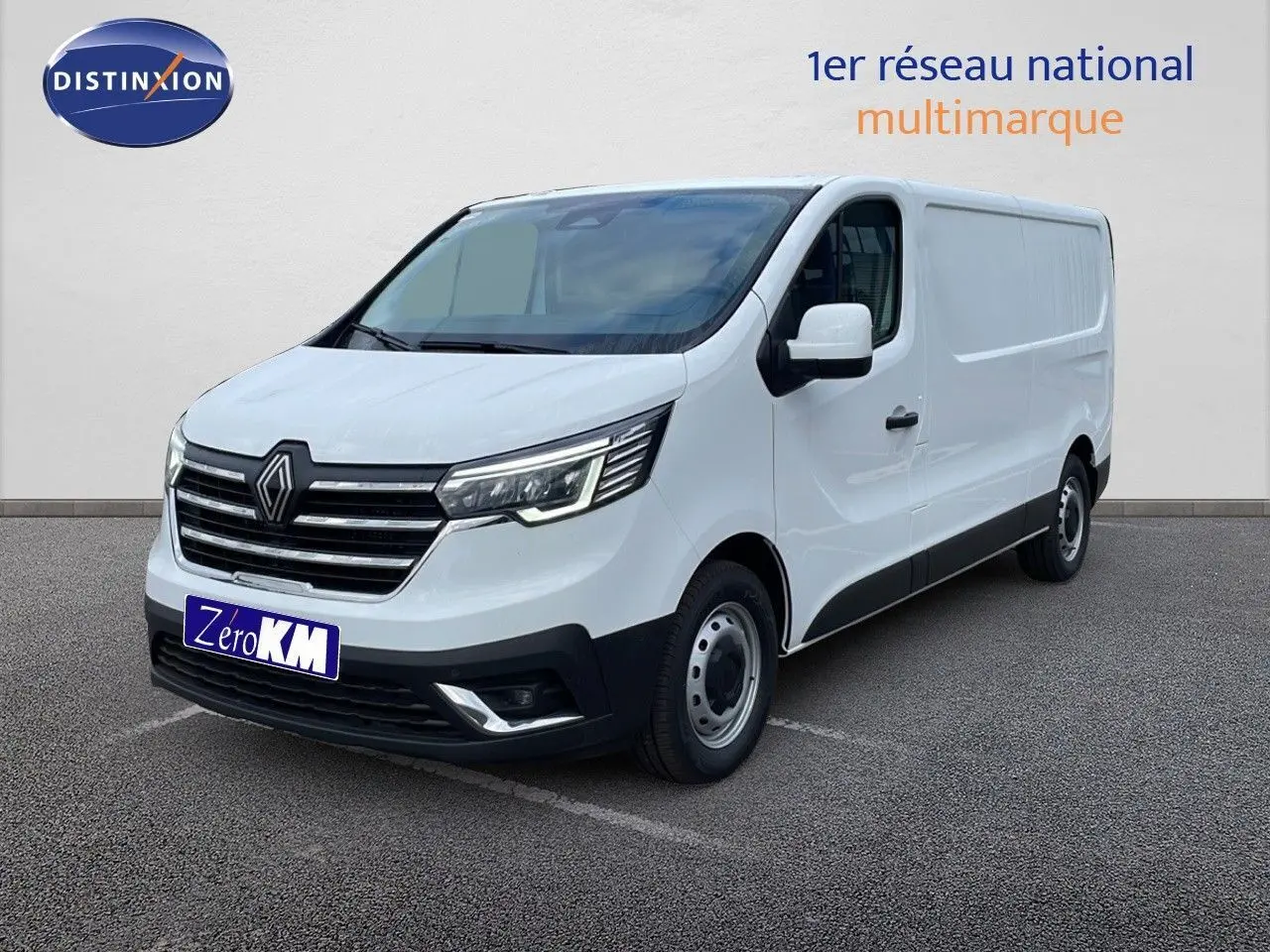 Renault Trafic Fourgon blanc glacier vu en 3/4 avant droit avec calandre noire et phares LED allumés.