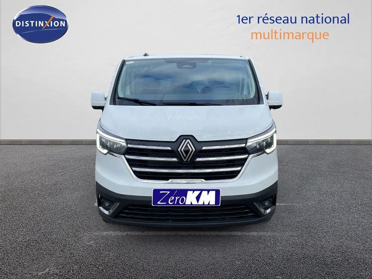 Vue frontale d'un Renault Trafic Fourgon blanc glacier avec calandre chromée et phares LED allumés.