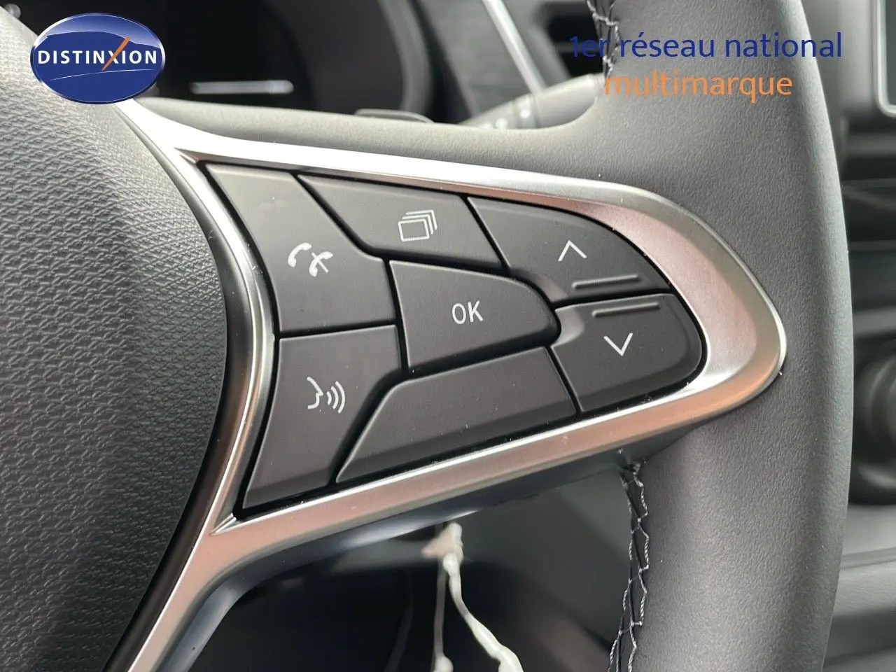 Gros plan sur les commandes multifonctions à droite du volant du Renault Trafic Fourgon blanc glacier 2025.