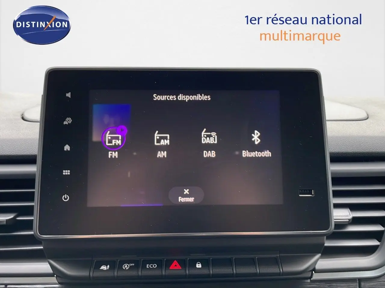 Écran tactile central du tableau de bord du Renault Trafic Fourgon blanc glacier, affichant les sources audio disponibles.