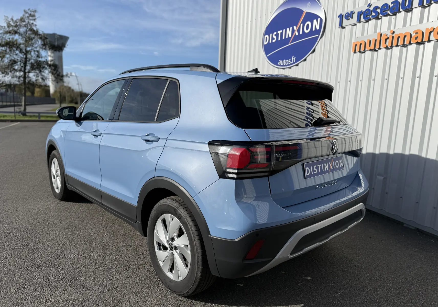 Vue latérale des sièges arrière en tissu gris clair du Volkswagen T-Cross 2024 bleu Sky Metal, intérieur spacieux et sobre.