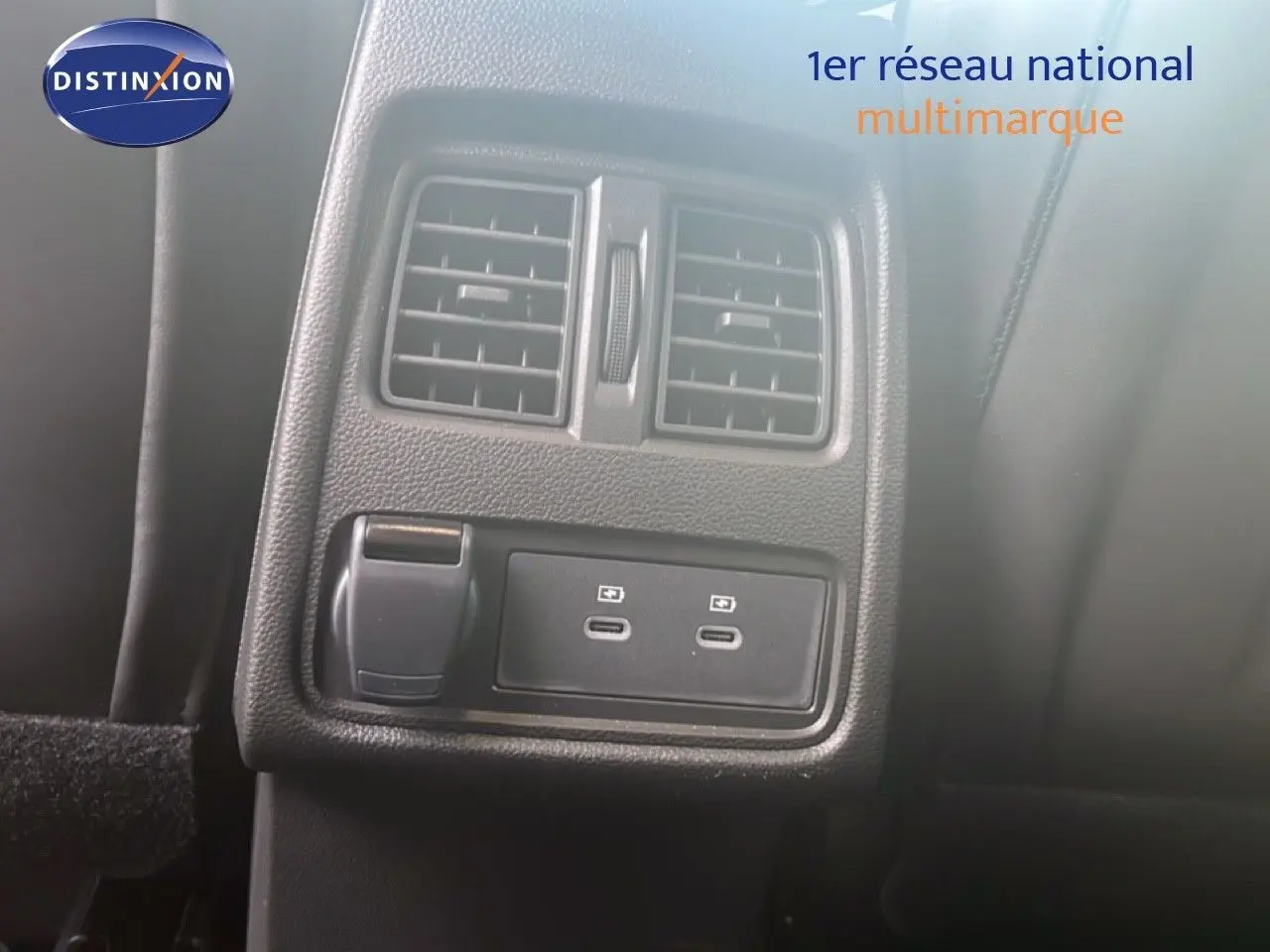 Gros plan sur la console arrière noire avec prises USB-C et bouches d’aération du Renault Symbioz blanc nacré 2025.