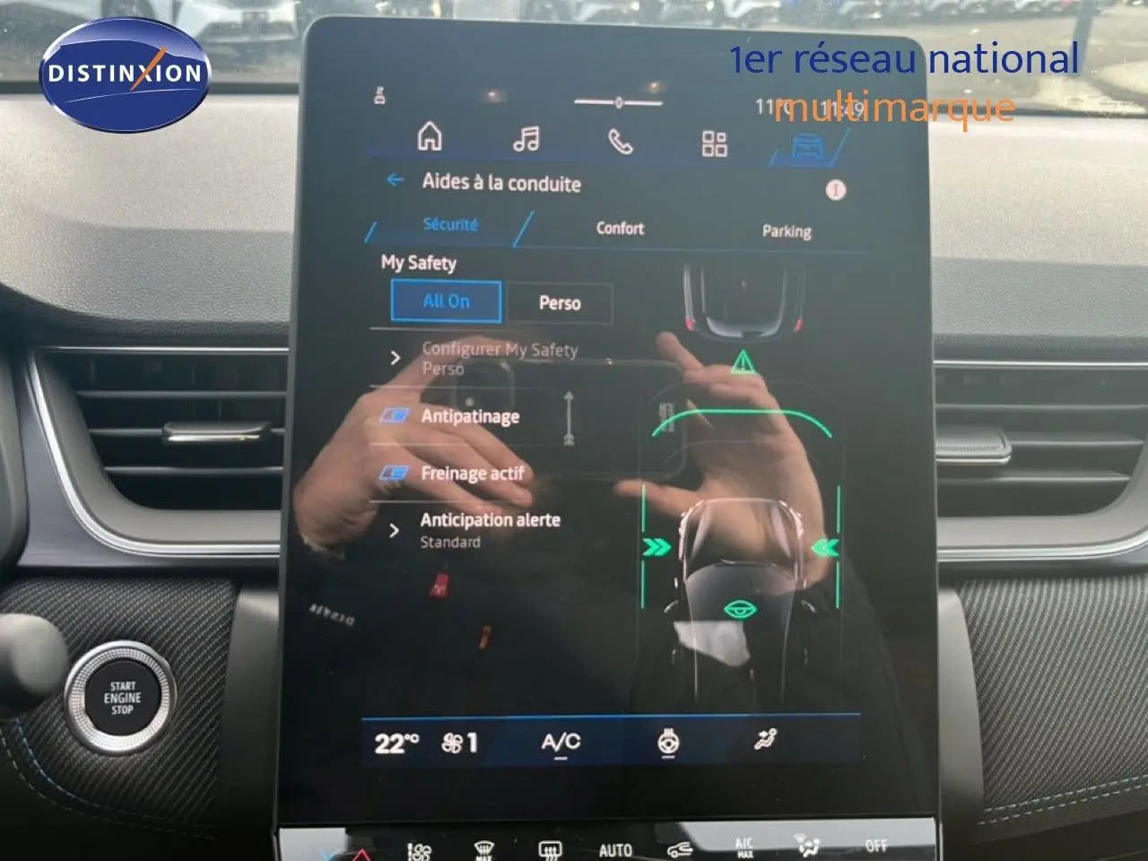 Vue intérieure centrée sur l'écran tactile du tableau de bord de la Renault Symbioz 2025 blanc nacré, affichant les aides à la conduite.