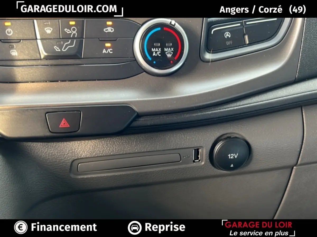 Détail de la console centrale du Ford Transit Custom blanc, montrant les commandes de climatisation et prise USB 12V.