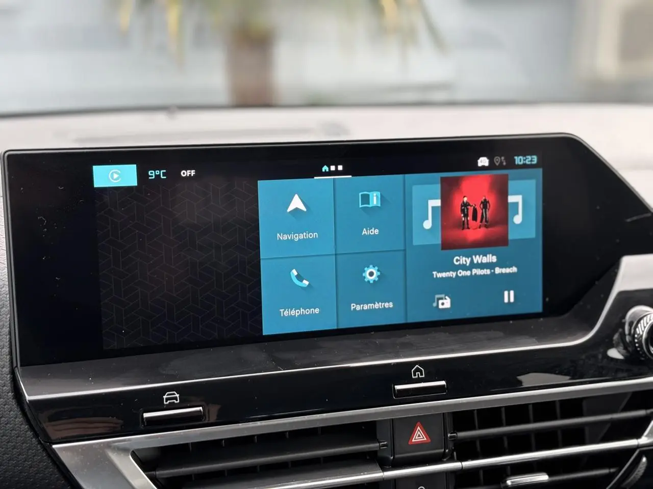 Écran tactile 10 pouces du tableau de bord Citroën C4 2024, affichant navigation et musique, ambiance intérieure noire.