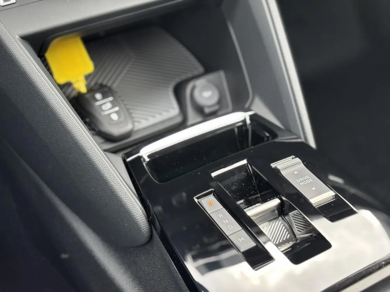 Gros plan sur la console centrale noire brillante de la Citroën C4 PureTech 130, avec sélecteur de mode de conduite.