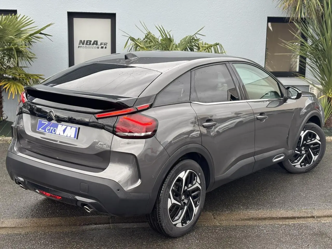 Vue 3/4 arrière droite d'une Citroën C4 2024 gris Platinium avec jantes alliage et feux arrière LED distinctifs.