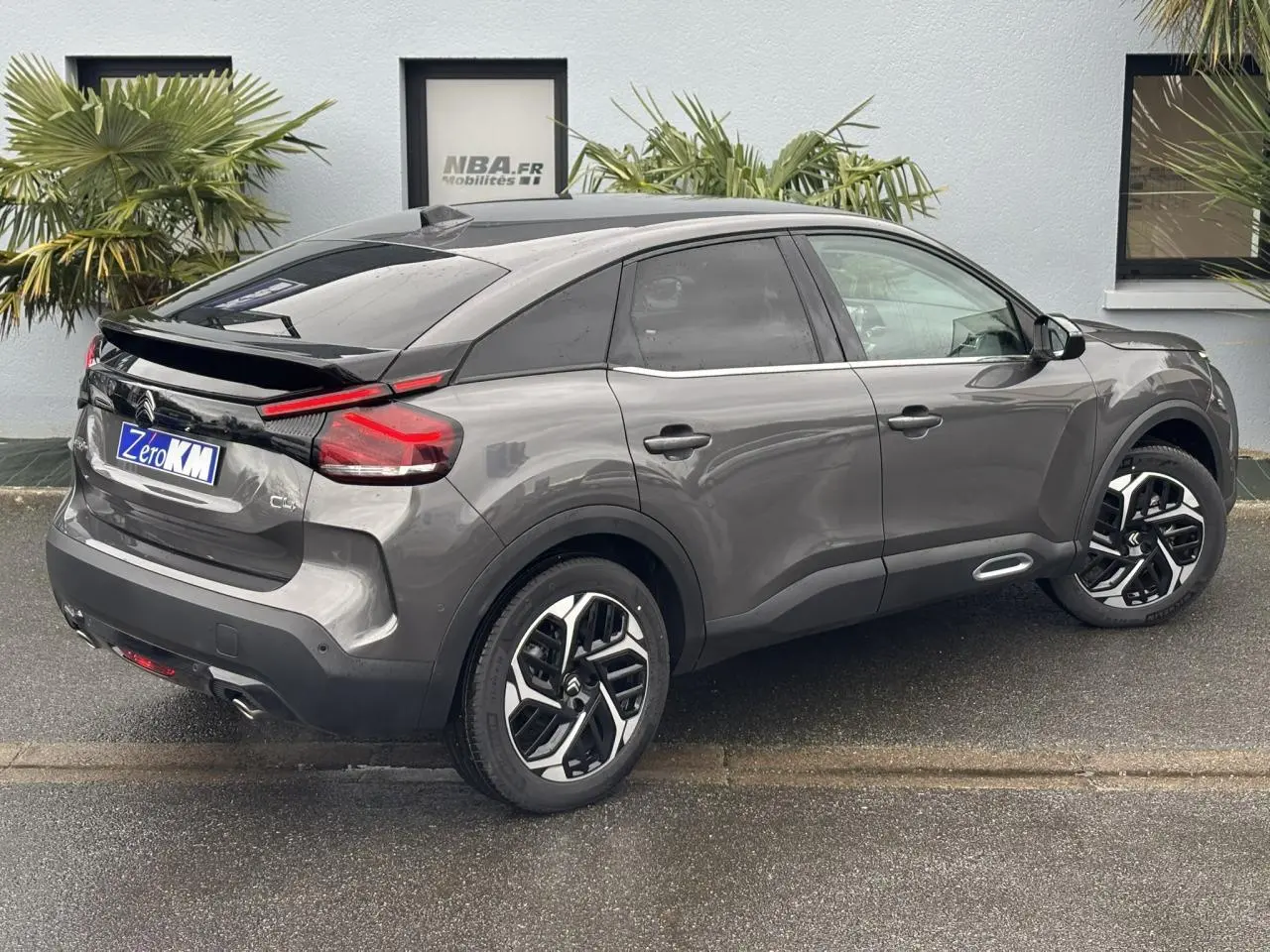 Vue 3/4 arrière droit d'une Citroën C4 2024 gris Platinium avec jantes alliage 18'' et vitres surteintées.