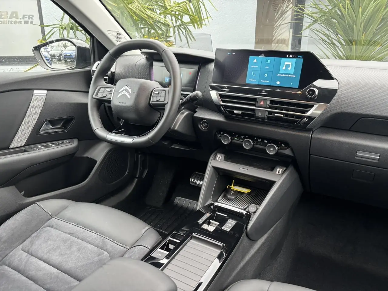 Intérieur avant droit de la Citroën C4 2024 avec volant cuir, écran tactile 10 pouces et sellerie Alcantara grise.
