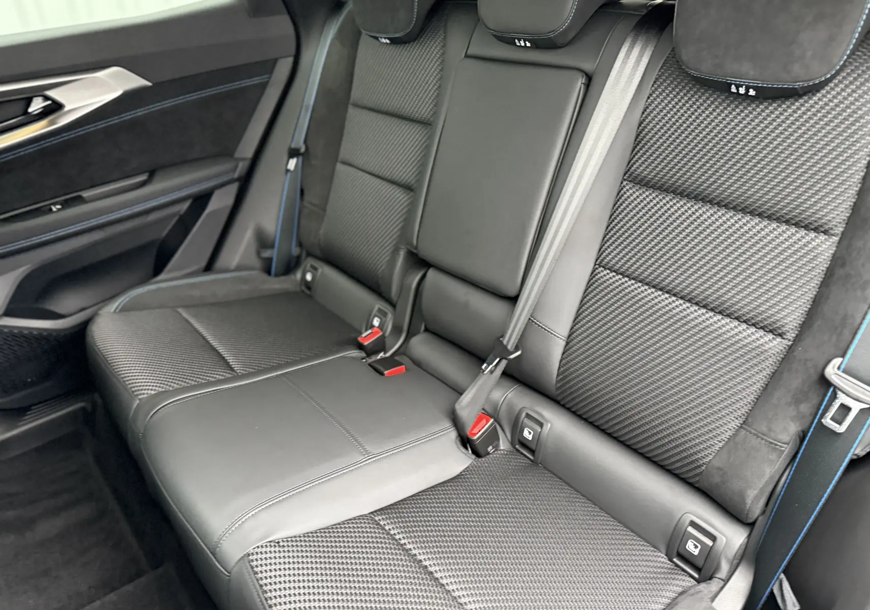 Vue intérieure des sièges arrière en cuir noir avec surpiqûres bleues du Renault Austral 2025 finition Esprit Alpine.