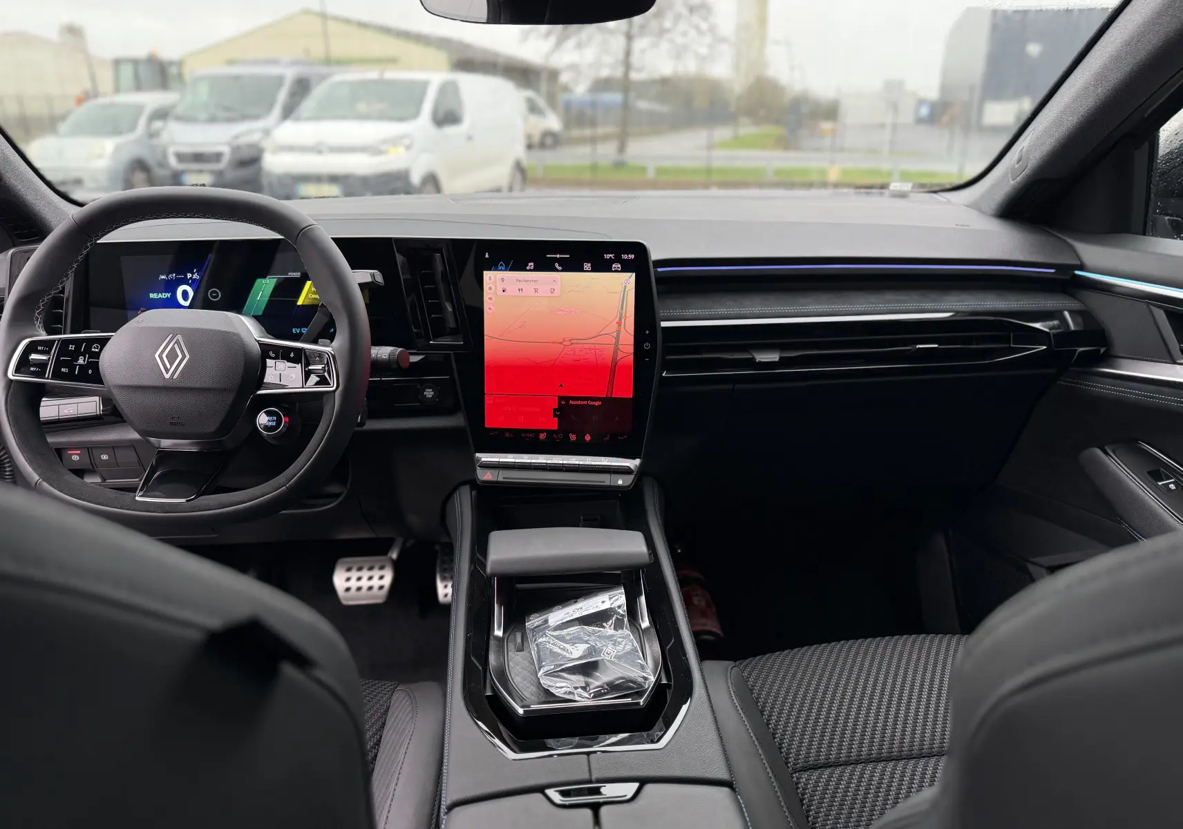 Vue intérieure avant du Renault Austral 2025, tableau de bord noir avec écran tactile vertical et volant multifonction.