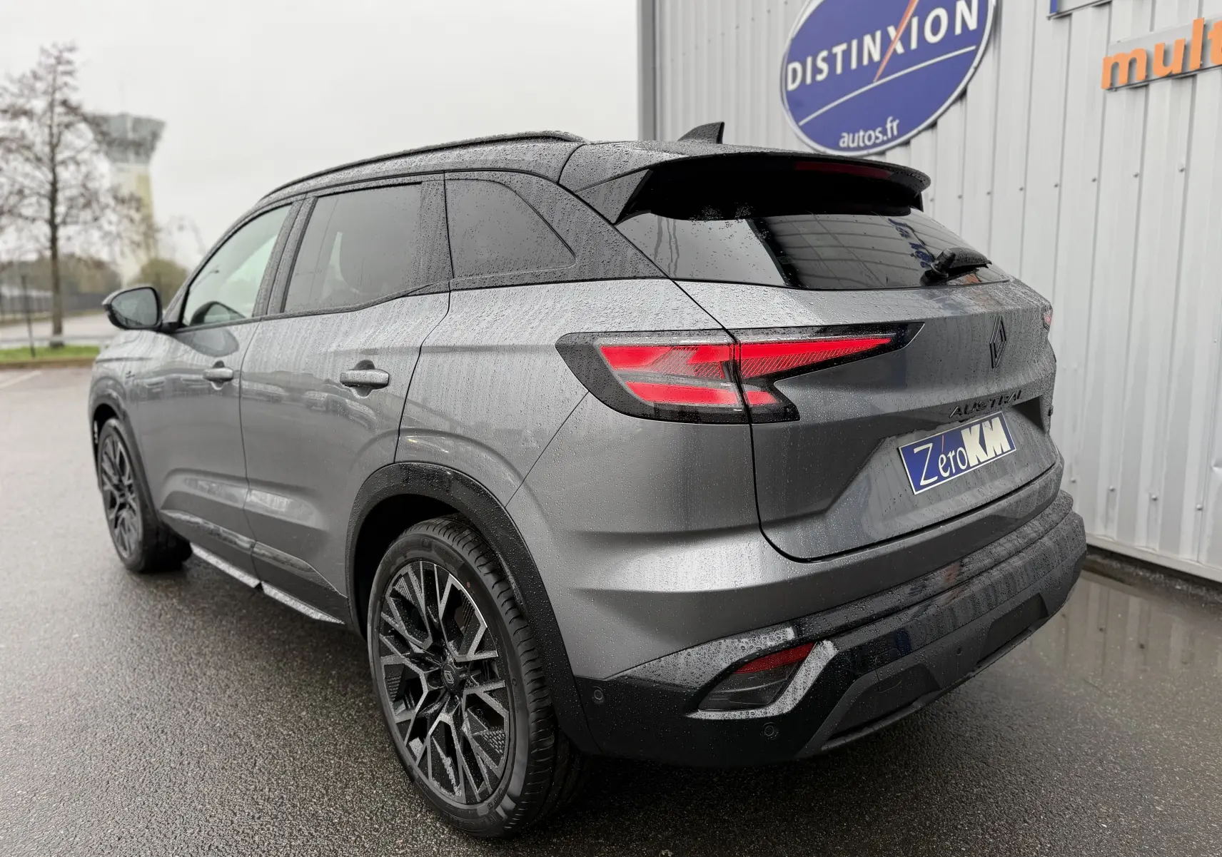 Vue 3/4 arrière droite du Renault Austral gris schiste avec toit noir et jantes noires au design sportif.