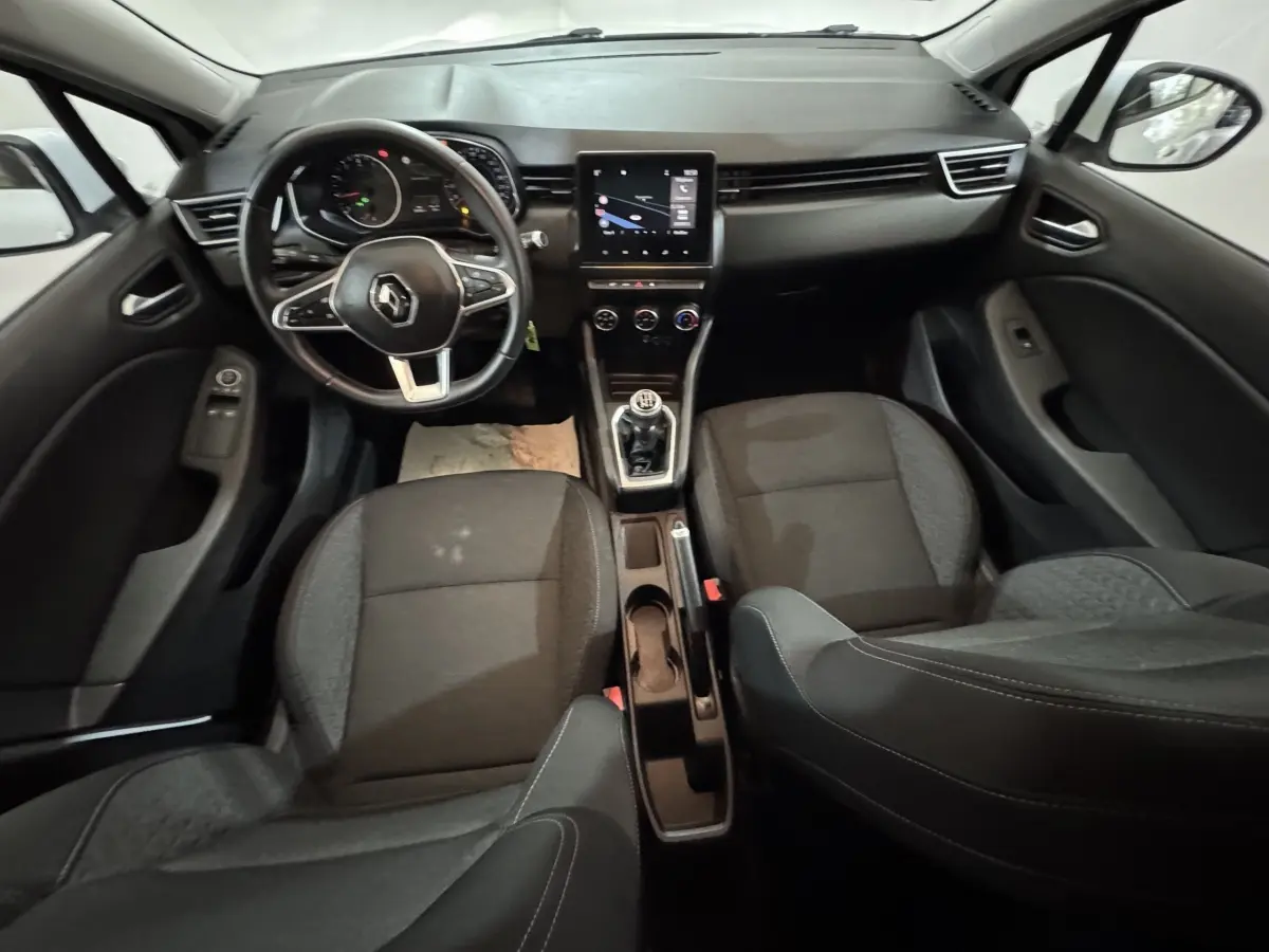 Vue intérieure avant de la Renault Clio Business TCe 100 2020, volant cuir, écran tactile central et sièges noirs.