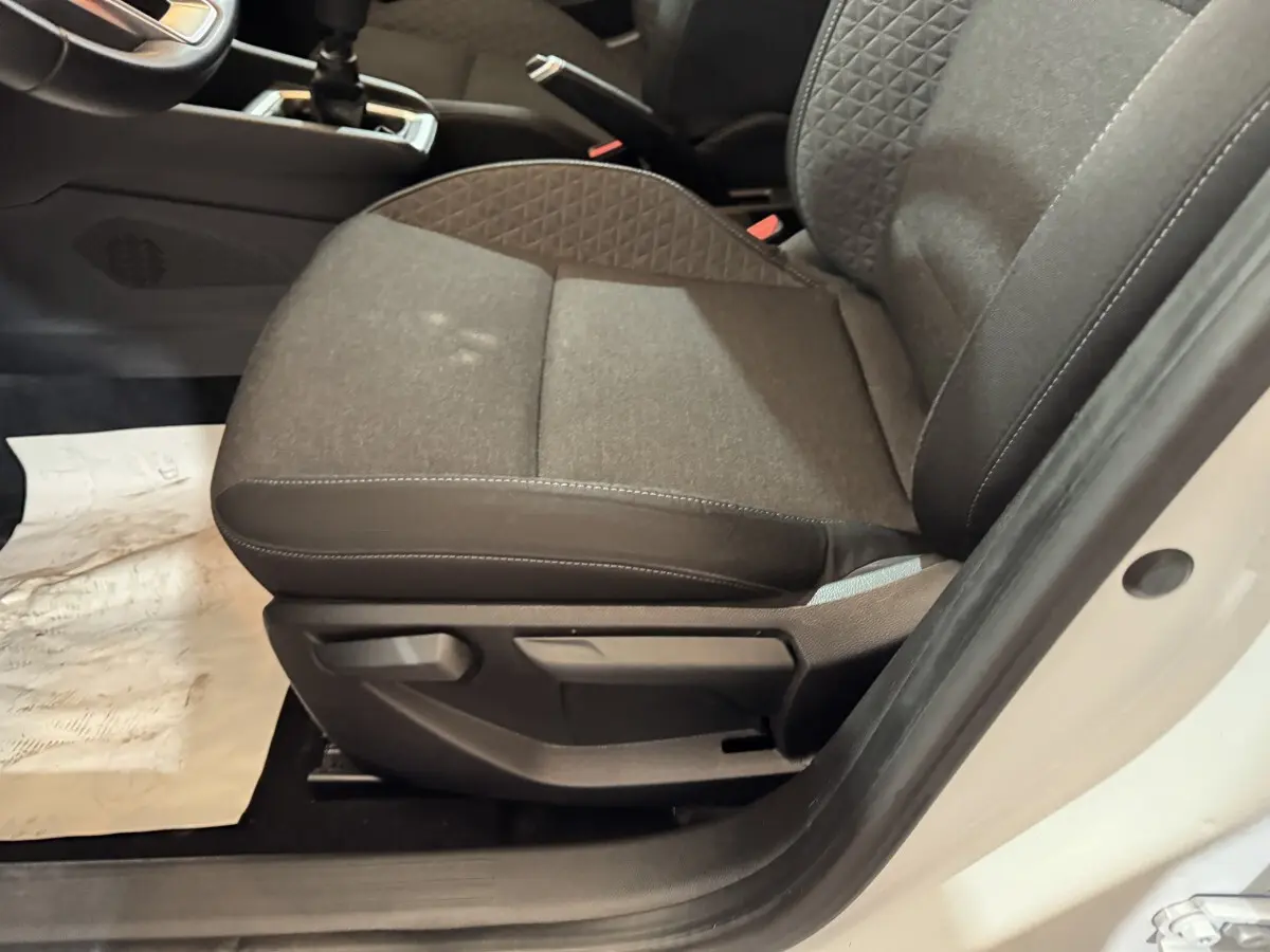 Vue rapprochée du siège avant droit gris foncé de la Renault Clio Business TCe 100 2020 avec portière blanche ouverte.