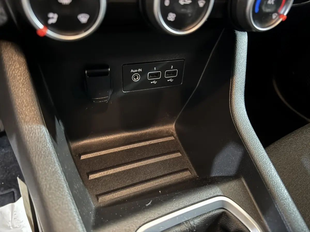 Vue rapprochée de la console centrale noire de la Renault Clio Business TCe 100 avec prises USB et entrée Aux-IN.