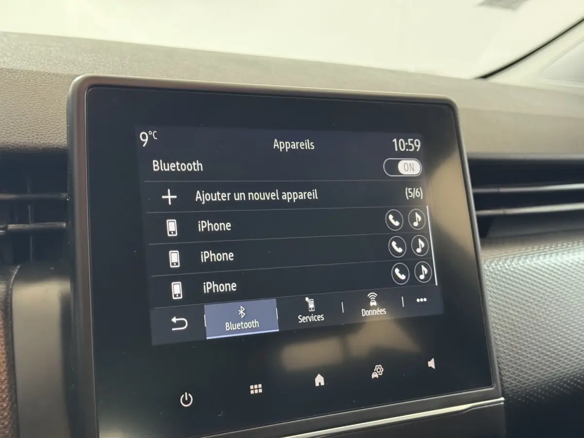Écran tactile central de la Renault Clio Business blanc de 2020 affichant le menu Bluetooth avec plusieurs iPhone connectés.
