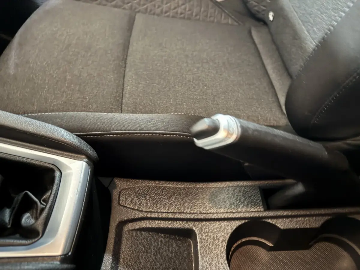 Gros plan sur le frein à main et la console centrale noire de la Renault Clio Business TCe 100 de 2020.