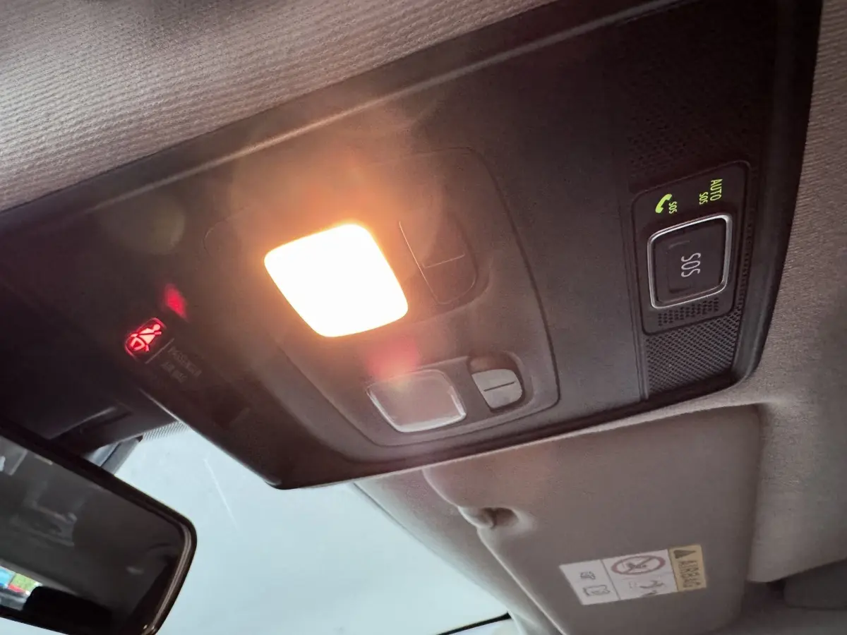 Plafonnier intérieur allumé avec bouton SOS et miroir de courtoisie dans une Renault Clio Business blanche.