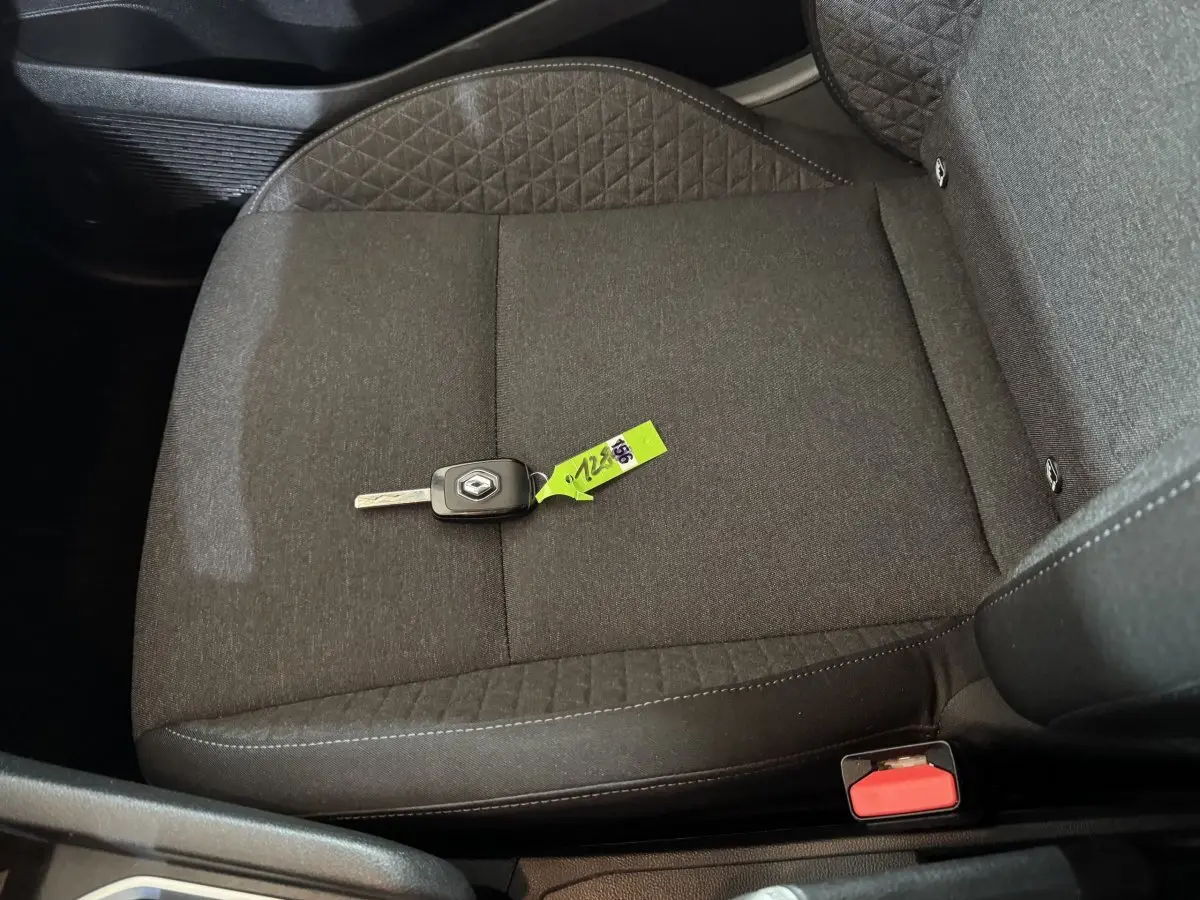 Vue rapprochée du siège avant droit gris foncé d'une Renault Clio avec clé de contact posée dessus.
