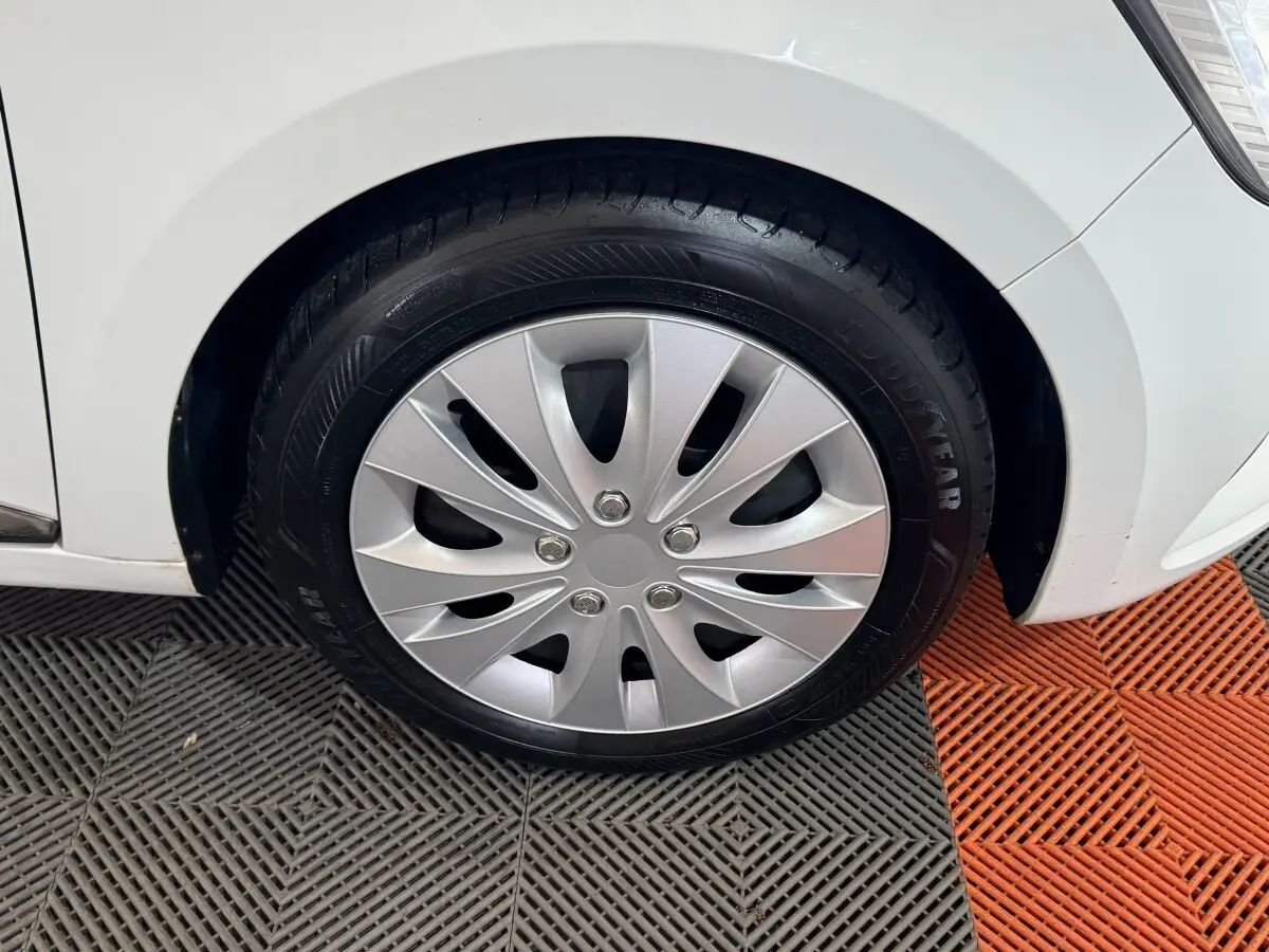 Gros plan sur la roue avant droite de la Renault Clio Business TCe 100 blanche, avec jante en plastique argenté.