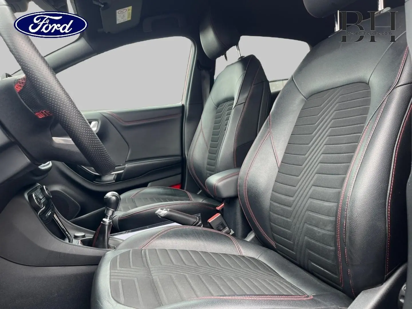 Intérieur Ford Puma 2020 vu côté droit, sièges sport en cuir noir avec surpiqûres rouges et levier de vitesse manuel.