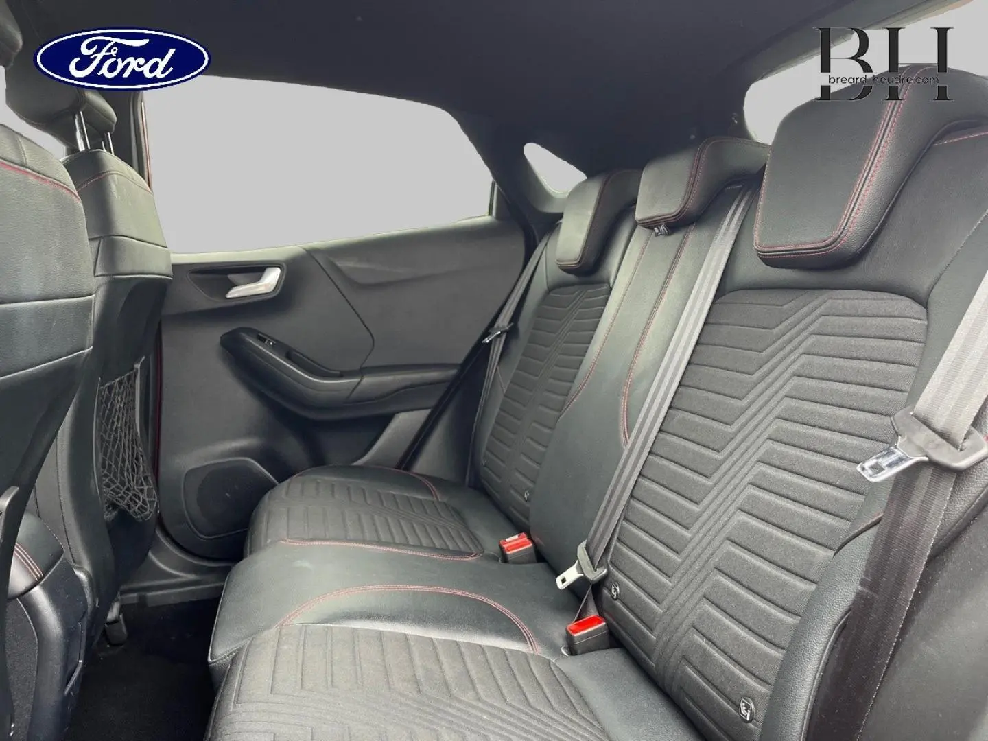 Vue intérieure montrant la banquette arrière en tissu noir avec surpiqûres rouges du Ford Puma 2020.