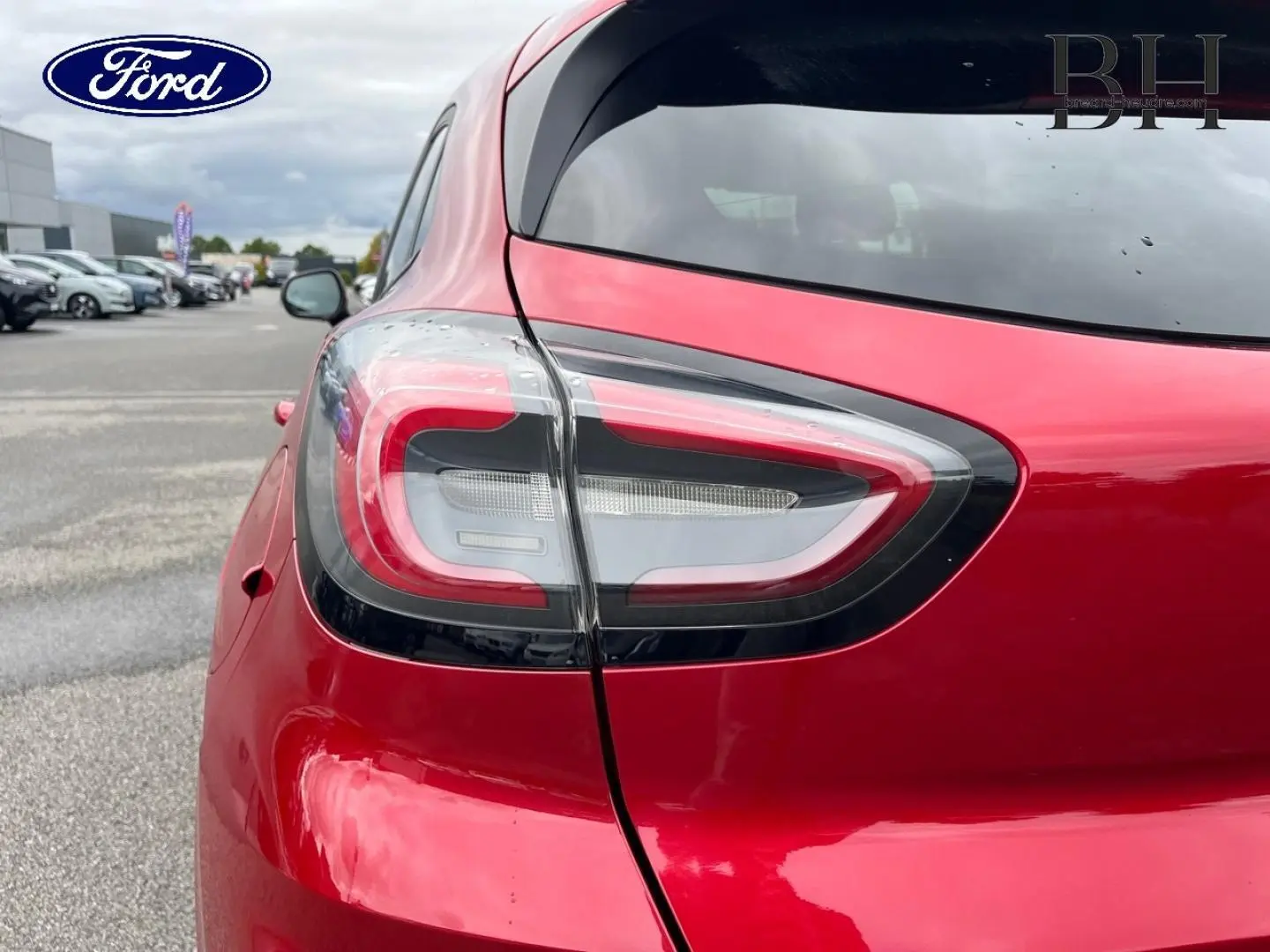Gros plan sur le feu arrière gauche d'un Ford Puma 2020 en Premium Rouge Lucid avec lunette arrière surteintée.
