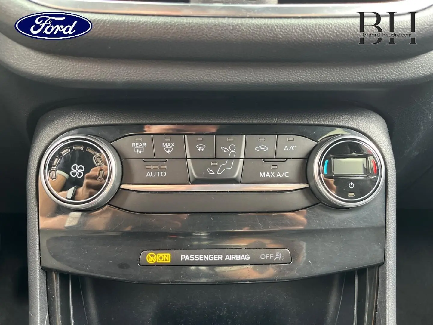 Gros plan sur la console de climatisation du Ford Puma 2020, boutons et réglages en noir brillant.