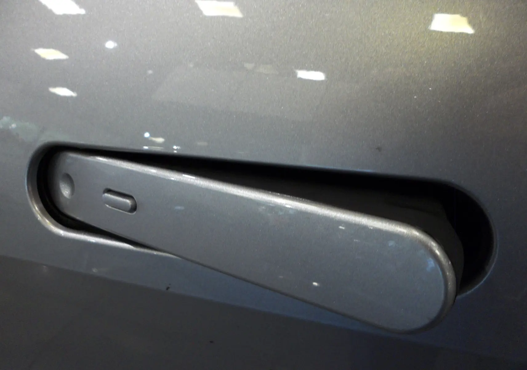 Poignée de porte gris minéral en gros plan sur Toyota C-HR Hybride 140 CH Style 2025, finition lisse et intégrée.