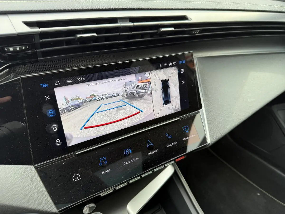 Écran tactile central affichant la caméra de recul et la vue 360° dans l'habitacle d'une Peugeot 408 blanche.