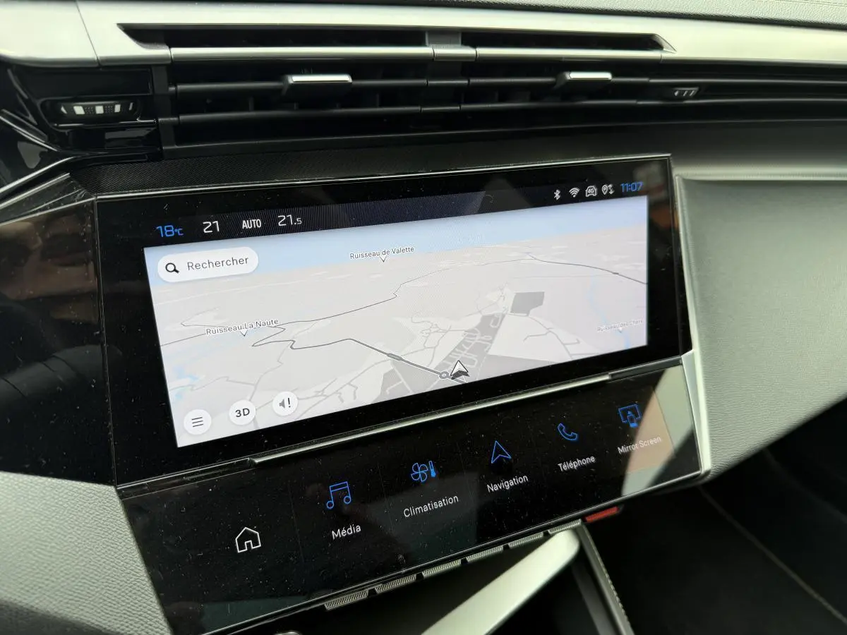 Écran tactile central 10 pouces du tableau de bord de la Peugeot 408 blanche, affichant la navigation GPS.