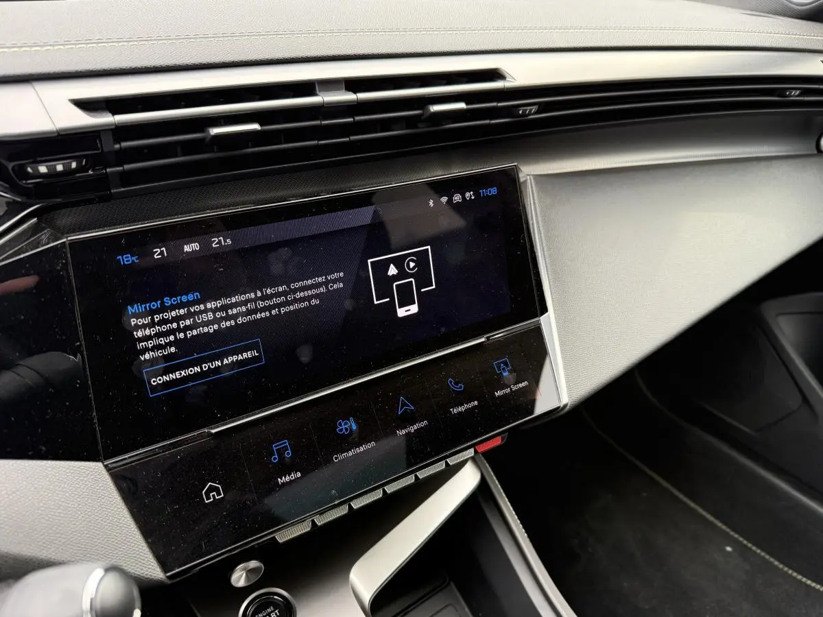 Vue rapprochée de la console centrale et écran tactile 10'' du Peugeot 408 blanc avec finitions gris clair et noir brillant