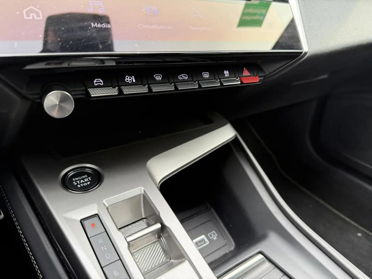 Console centrale argentée avec boutons de commande et écran tactile dans l'habitacle du Peugeot 408 blanc 2024.