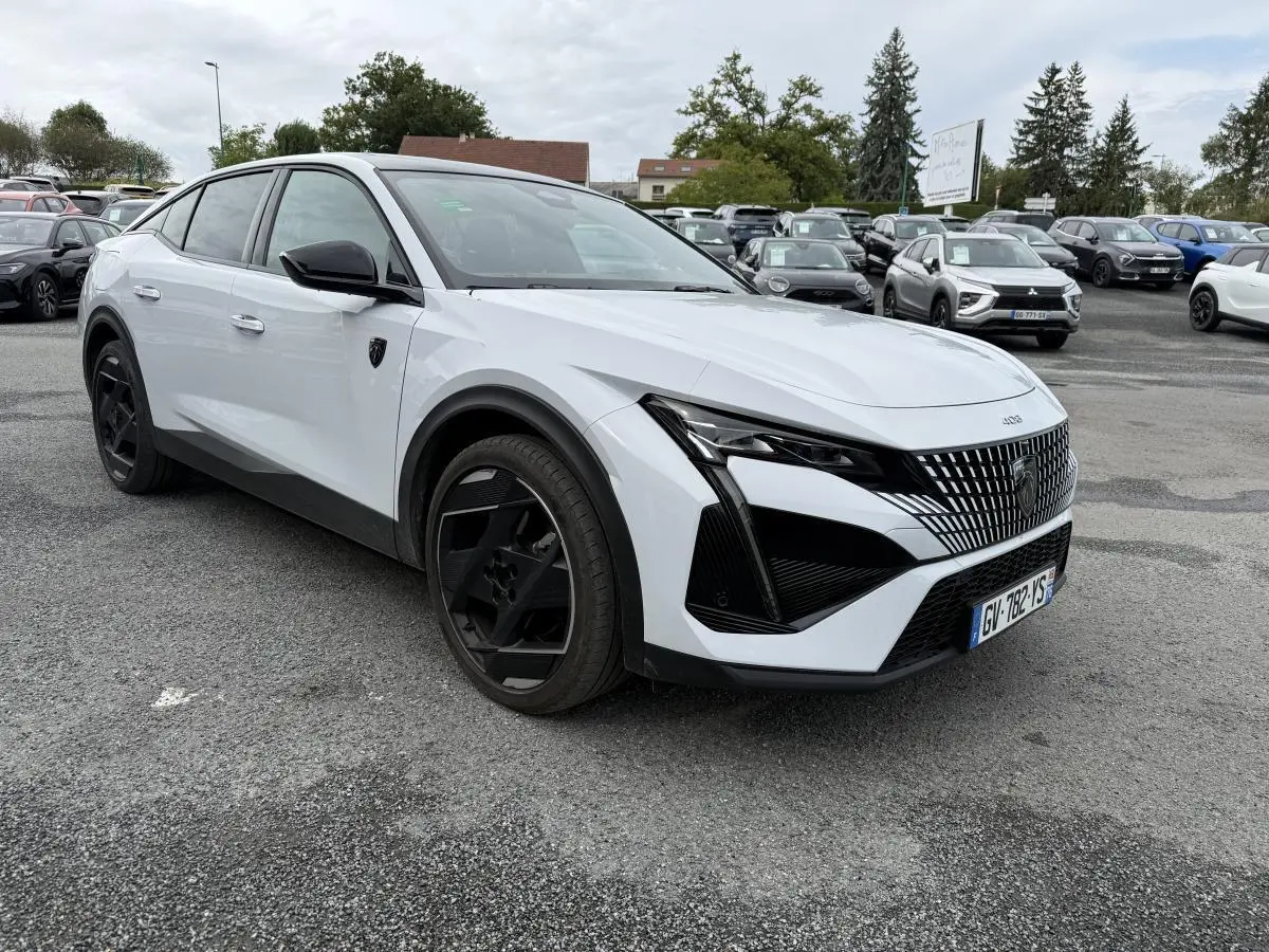 Peugeot 408 blanche vue 3/4 avant droit avec calandre noire et jantes alliage 19 pouces diamantées.