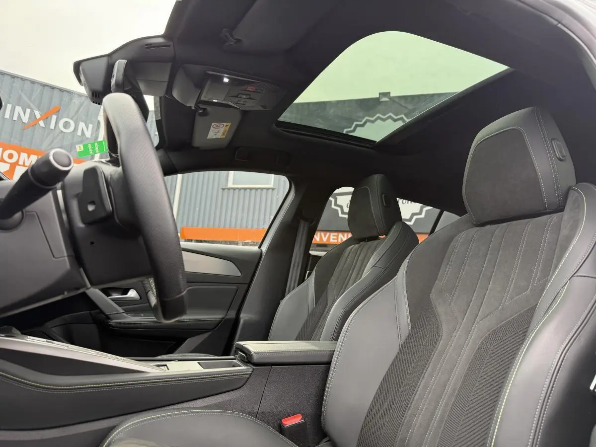 Intérieur de la Peugeot 408 blanc, vue côté gauche sur sièges sport en tri-matière et toit panoramique noir.