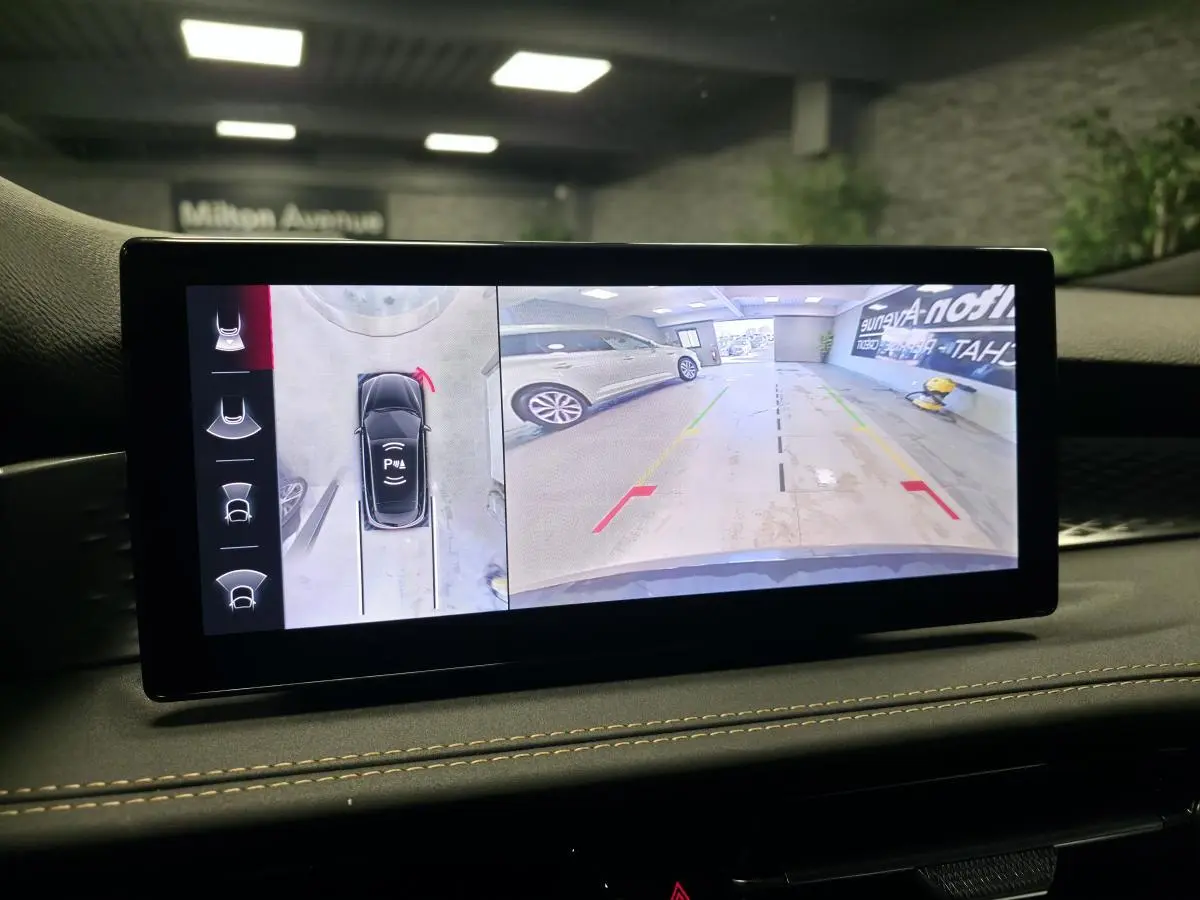 Écran intérieur affichant la caméra 360° et l'aide au stationnement du tableau de bord de l'Alfa Romeo Tonale bleu.