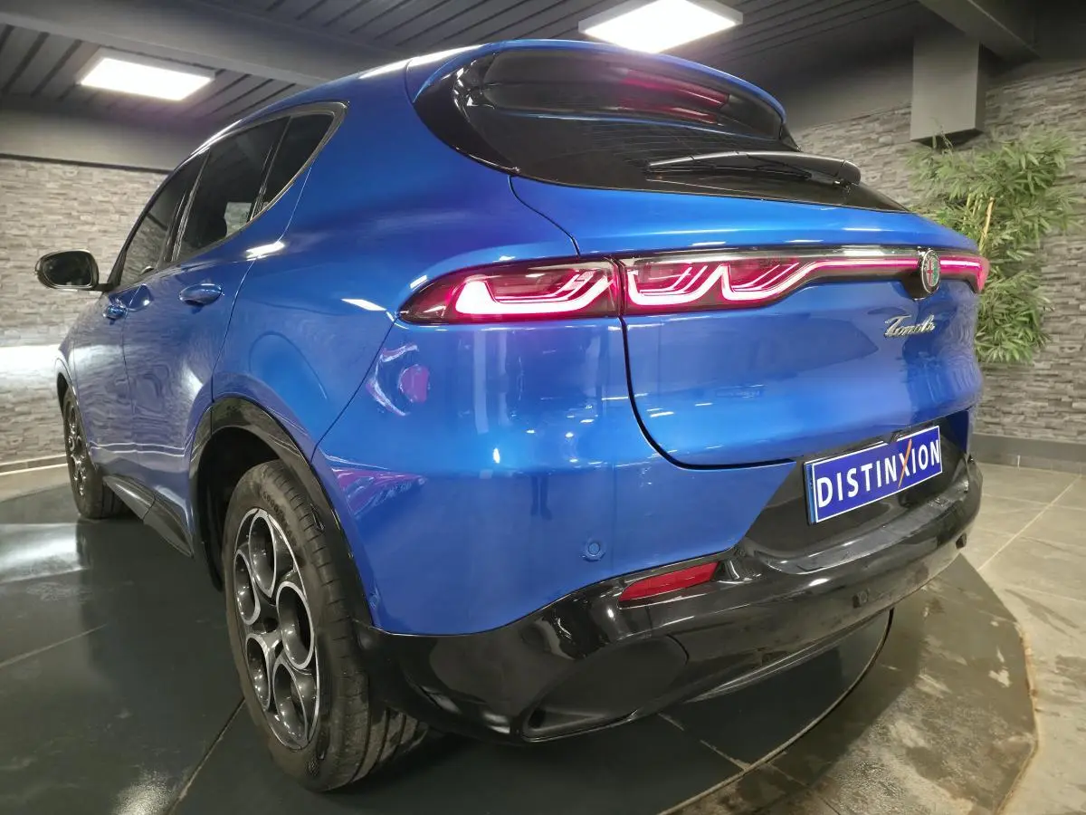 Vue 3/4 arrière droite de l'Alfa Romeo Tonale bleu avec feux arrière LED et jantes alliage 18 pouces.