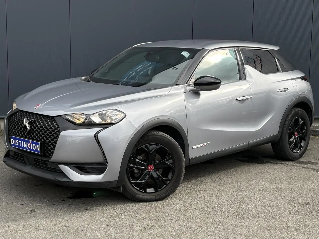 DS3 Crossback gris Artense en 3/4 avant droit, avec jantes noires et calandre distinctive DS Performance Line.