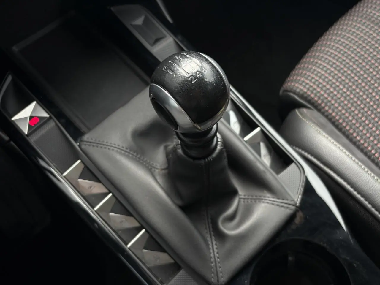 Le levier de vitesses manuel du DS3 Crossback 1.5 BlueHDI 110, avec console noire et siège tissu à motifs.