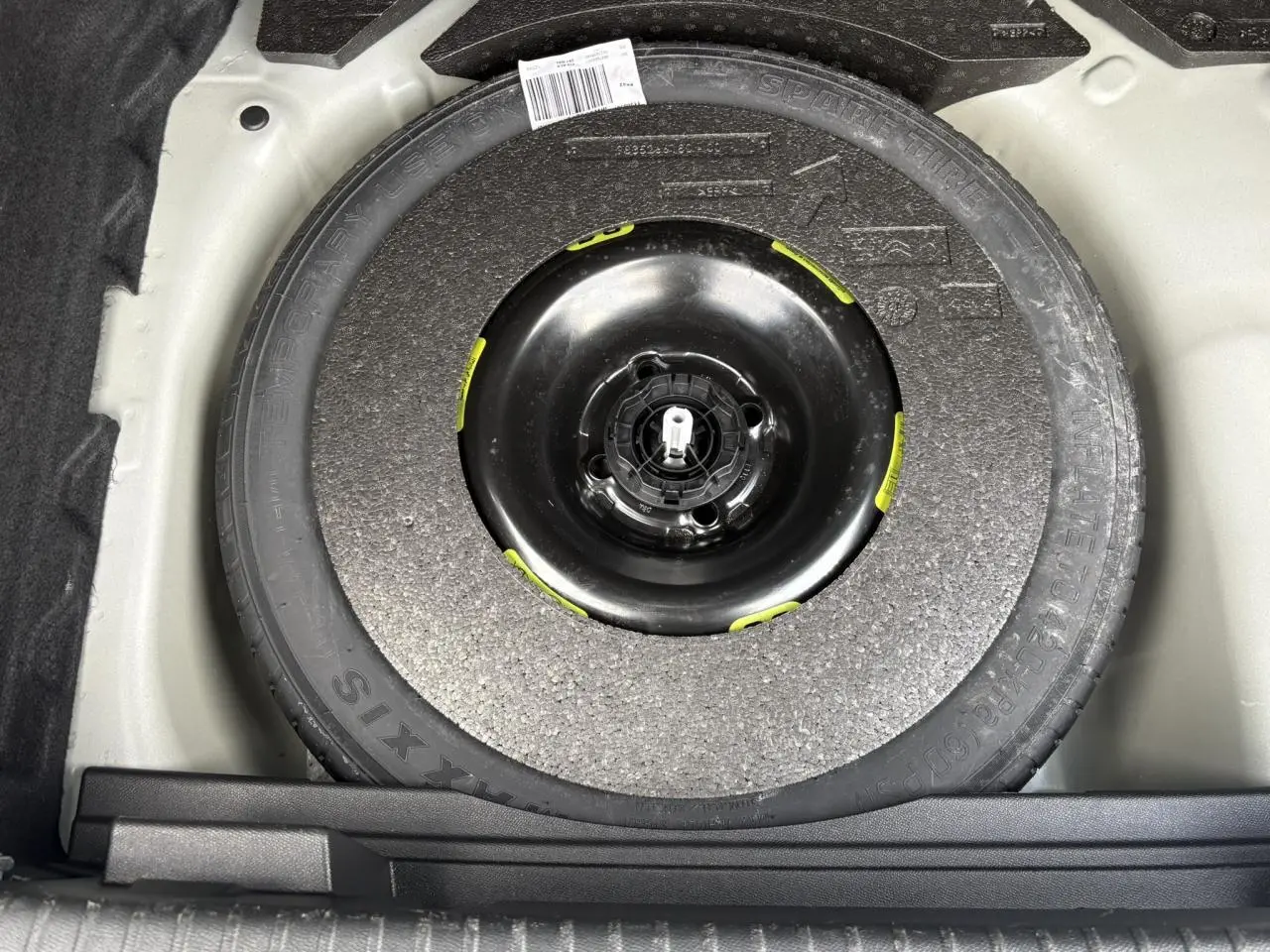 Gros plan sur la roue de secours galette noire dans le coffre du DS3 Crossback gris Artense 2021.