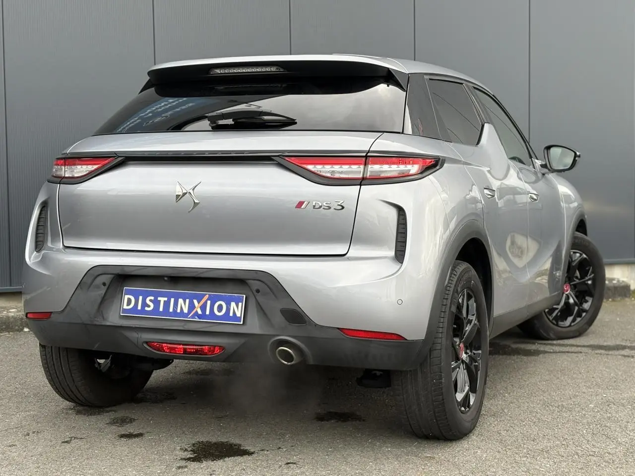 Vue 3/4 arrière droite d’un DS3 Crossback gris Artense avec jantes noires et feux arrière LED distinctifs.