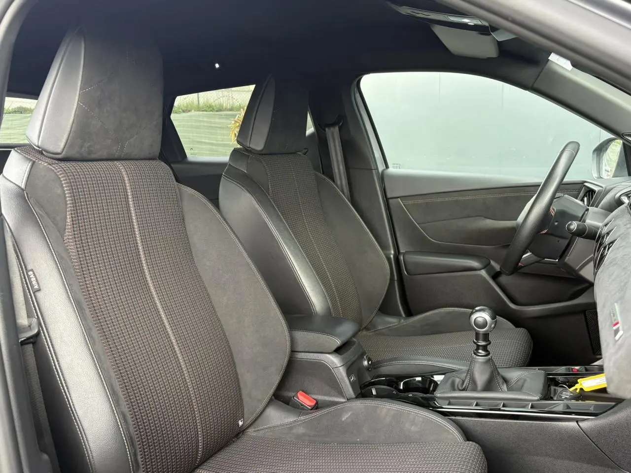 Vue intérieure côté droit du DS3 Crossback 2021, sièges en tissu et cuir noir avec surpiqûres contrastantes.